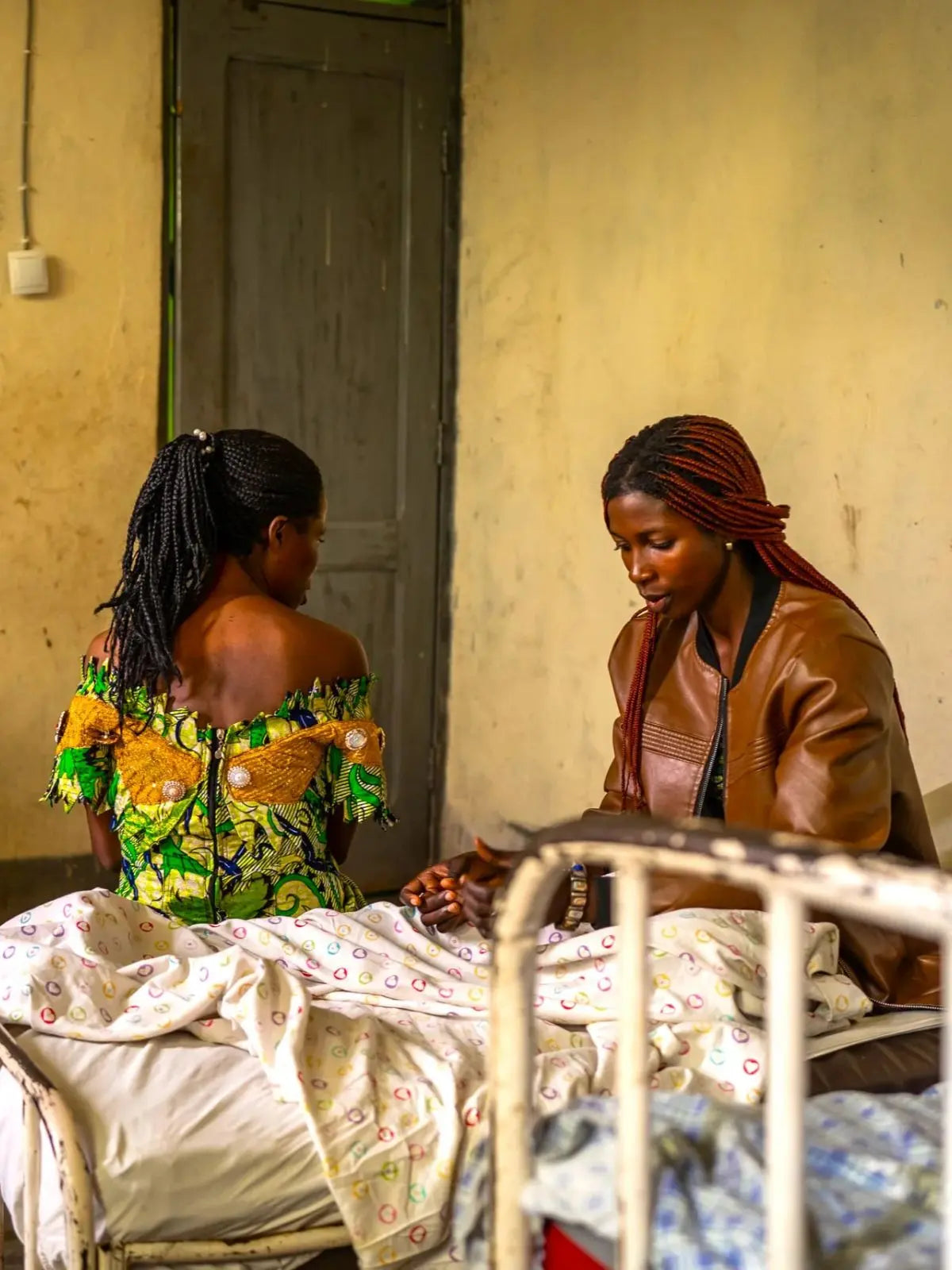 Two woman sat on a hospital bed inside the Hospital of Hope, Idjwi Island, DRC