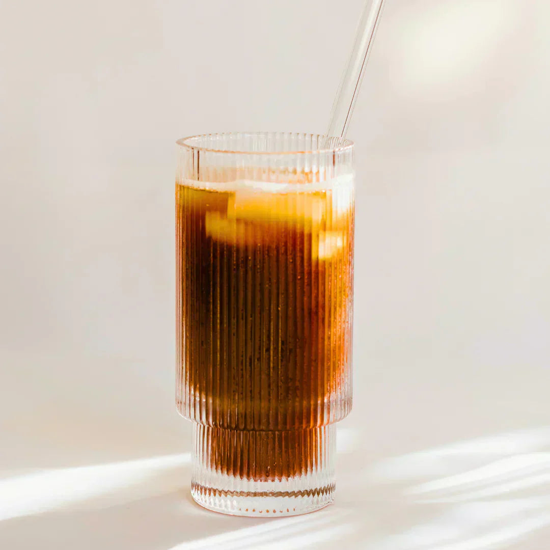 Iced coffee in a glass with ice and a straw