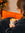 Girl sat on orange sofa with Mozzo coffee latte with Christmas tree bokeh in the background