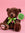 Brown teddy bear with white coffee bean stitched into foot with green ribbon round it's neck