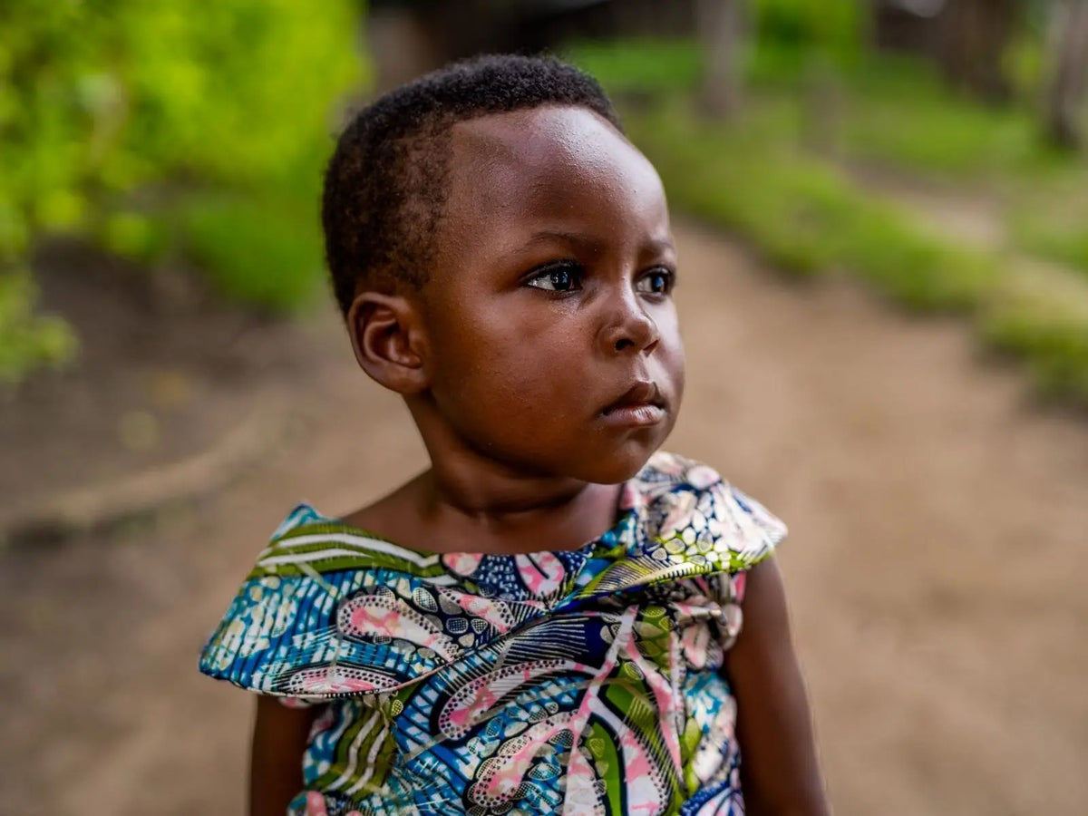 Medium close-up of a young girl named Noella, the first baby born in the Mozzo funded Hospital of Hope, DRC
